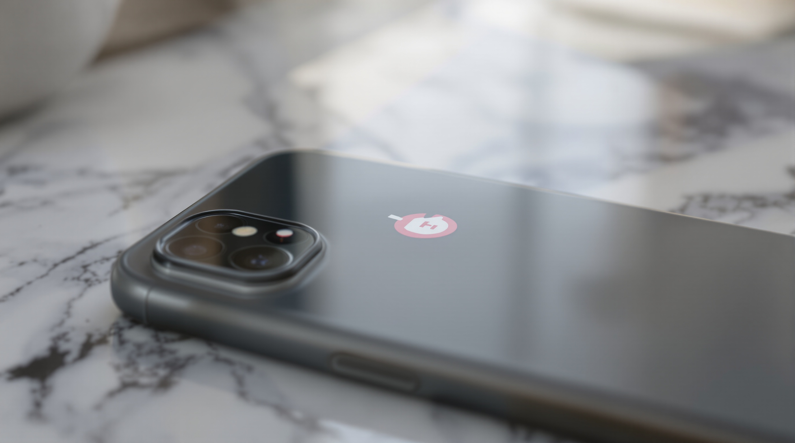 A phone screen showing a storage notification with a red progress bar, photographed on a marble countertop with natural side lighting, tight crop detail shot