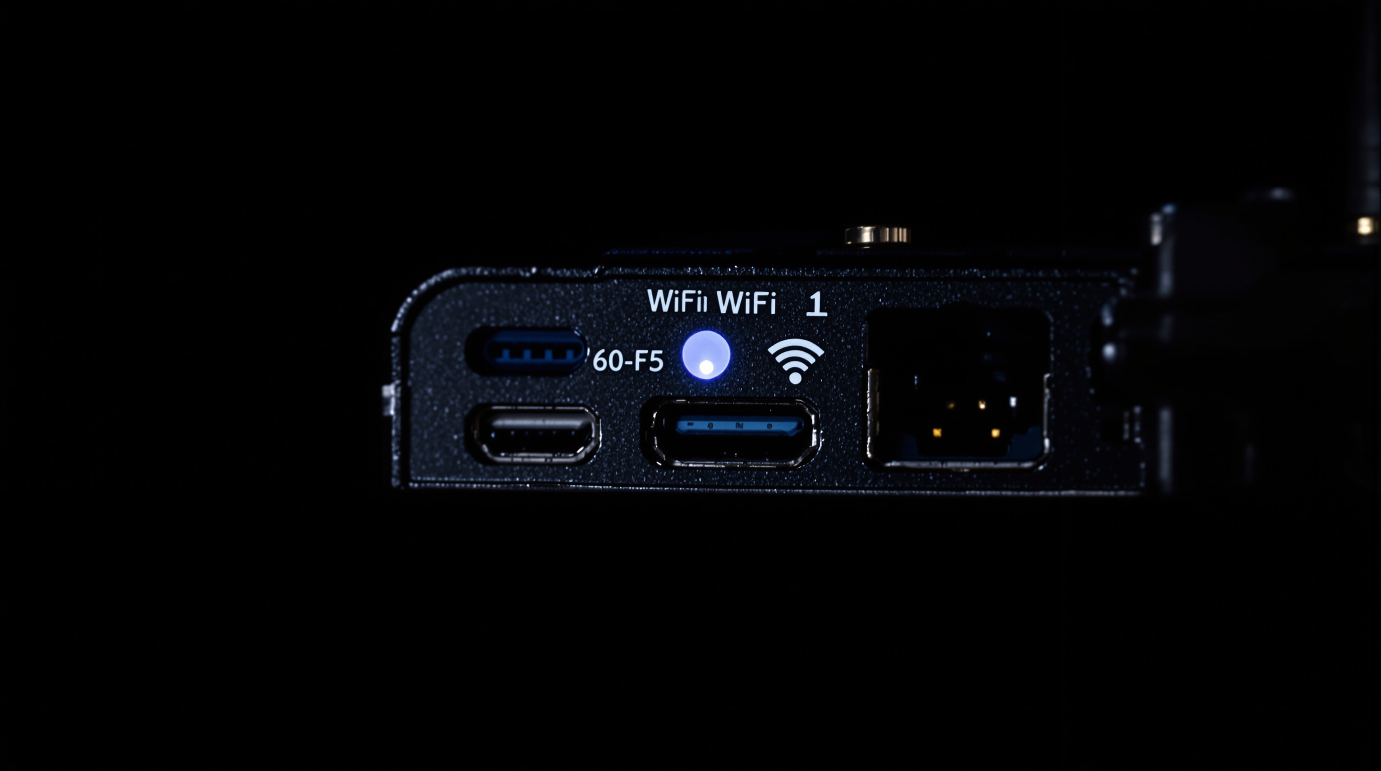 Close-up of a WiFi router with blinking indicator lights next to a digital photo frame on a side table