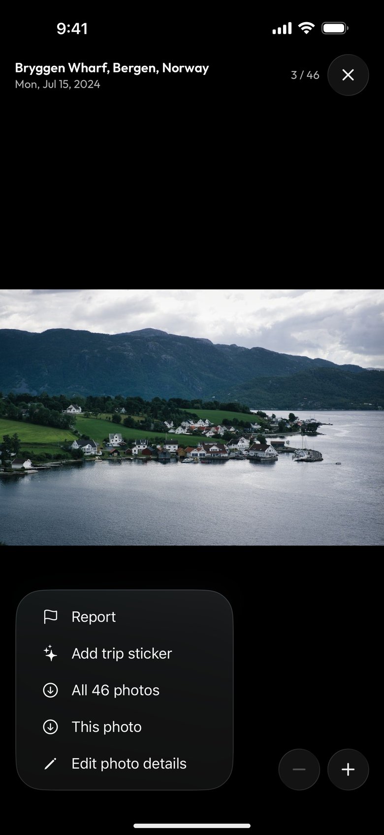 A photo of a fjord village from the same album open in the photo viewer on a phone, Bryggen Wharf, Bergen, Norway, Mon, Jul 15, 2024, 3 / 46, with the ⋯ menu open at the bottom left on Report, Add trip sticker, All 46 photos, This photo and Edit photo details