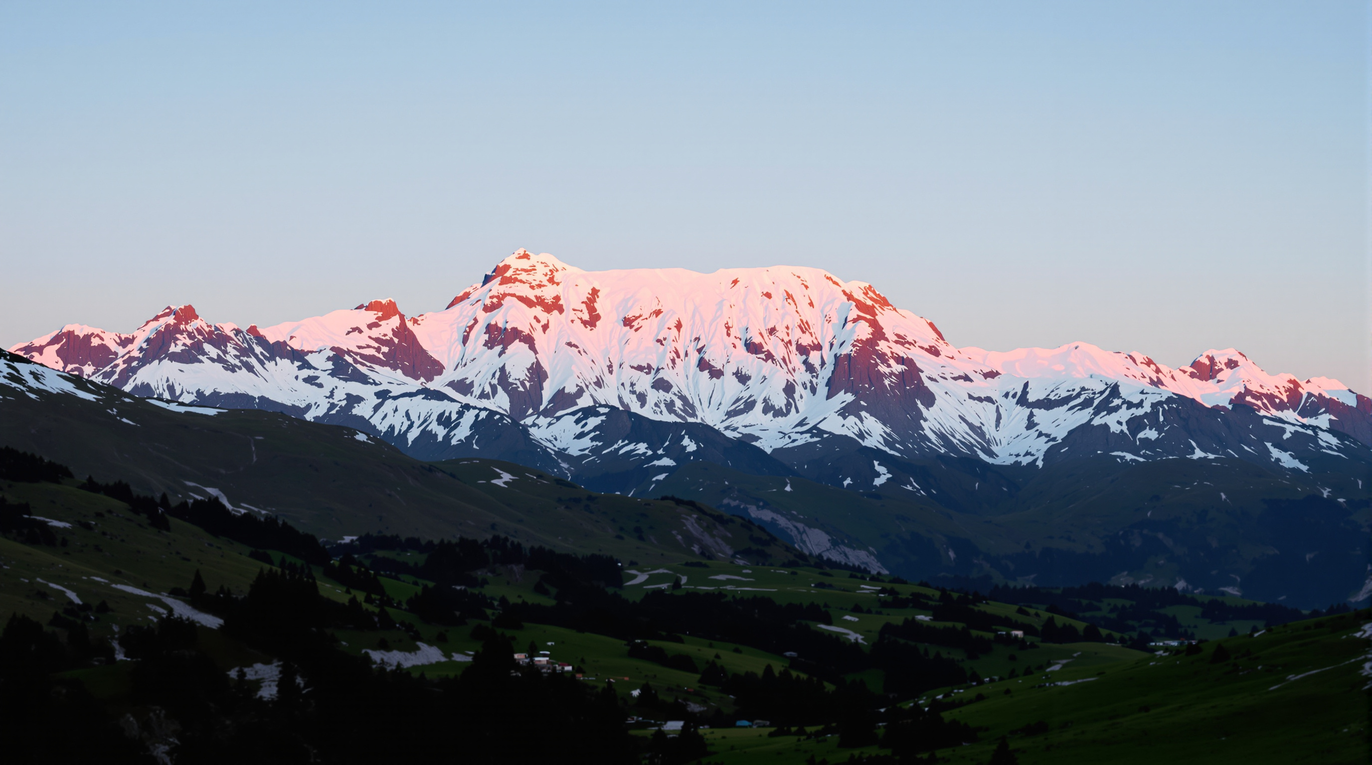 Snow-capped peaks glowing pink at sunrise above a green valley