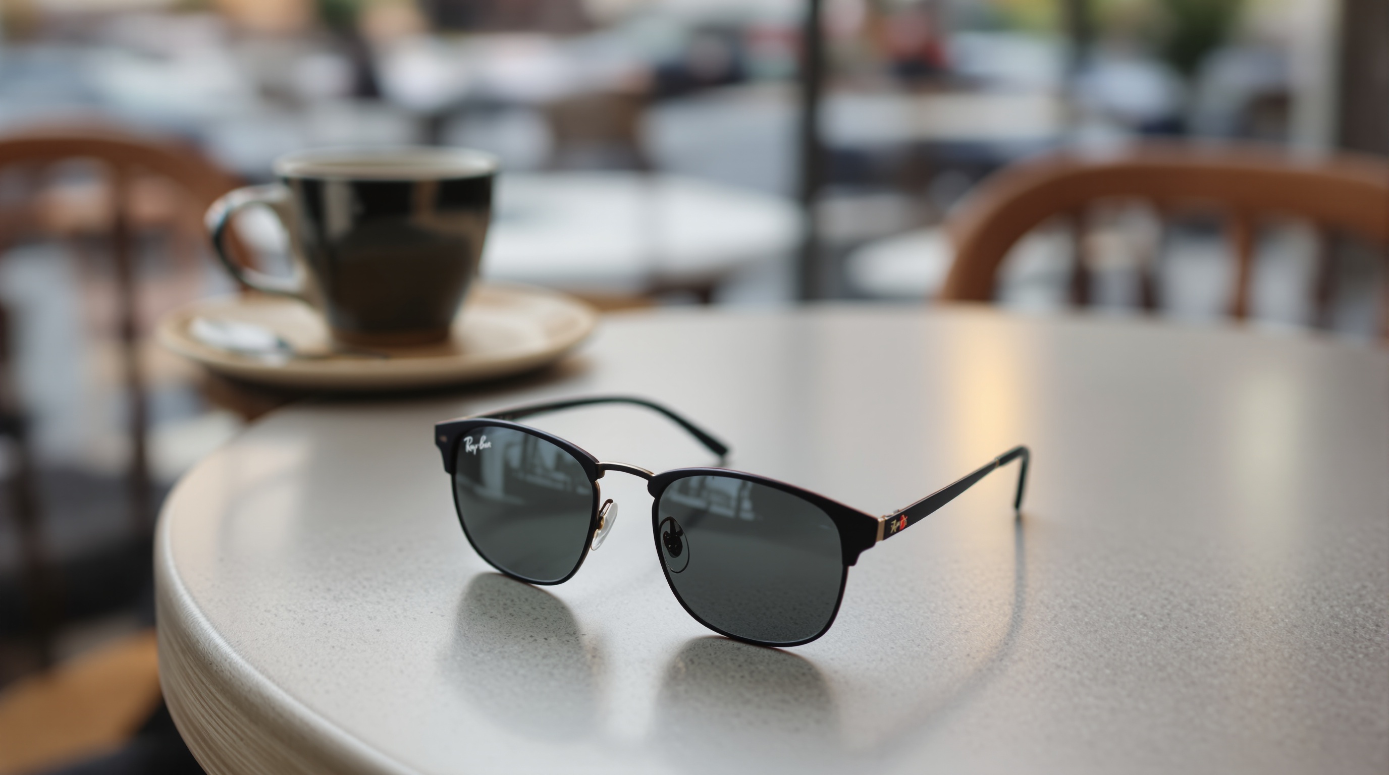 A pair of Ray-Ban smart glasses resting on a light wooden table next to a ceramic coffee cup, soft diffused window light, shot on Fujifilm X-T5 with 35mm f/1.4, shallow depth of field, warm neutral tones