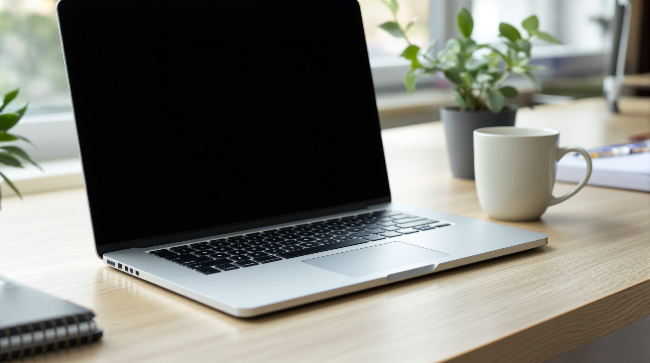 A laptop and a coffee mug on a clean desk, screen showing a photo gallery interface, editorial style